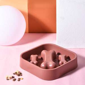 Pink silicone mold with bone shapes on a pink background