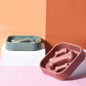 Two dog bowls, one green and one pink, on a colorful background