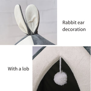 Cat house with rabbit ear decoration and a pom-pom detail on a gray background