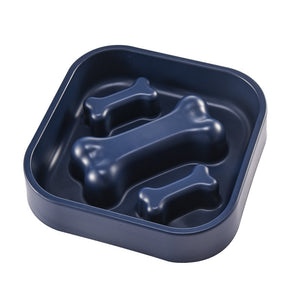 Navy blue pet food dish with bone-shaped compartments on a white background