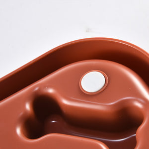 Brown plastic mold with a white circular component on a white background