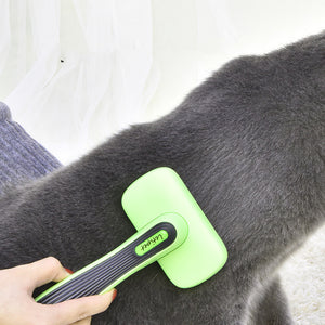Green pet grooming brush being used on a gray dog